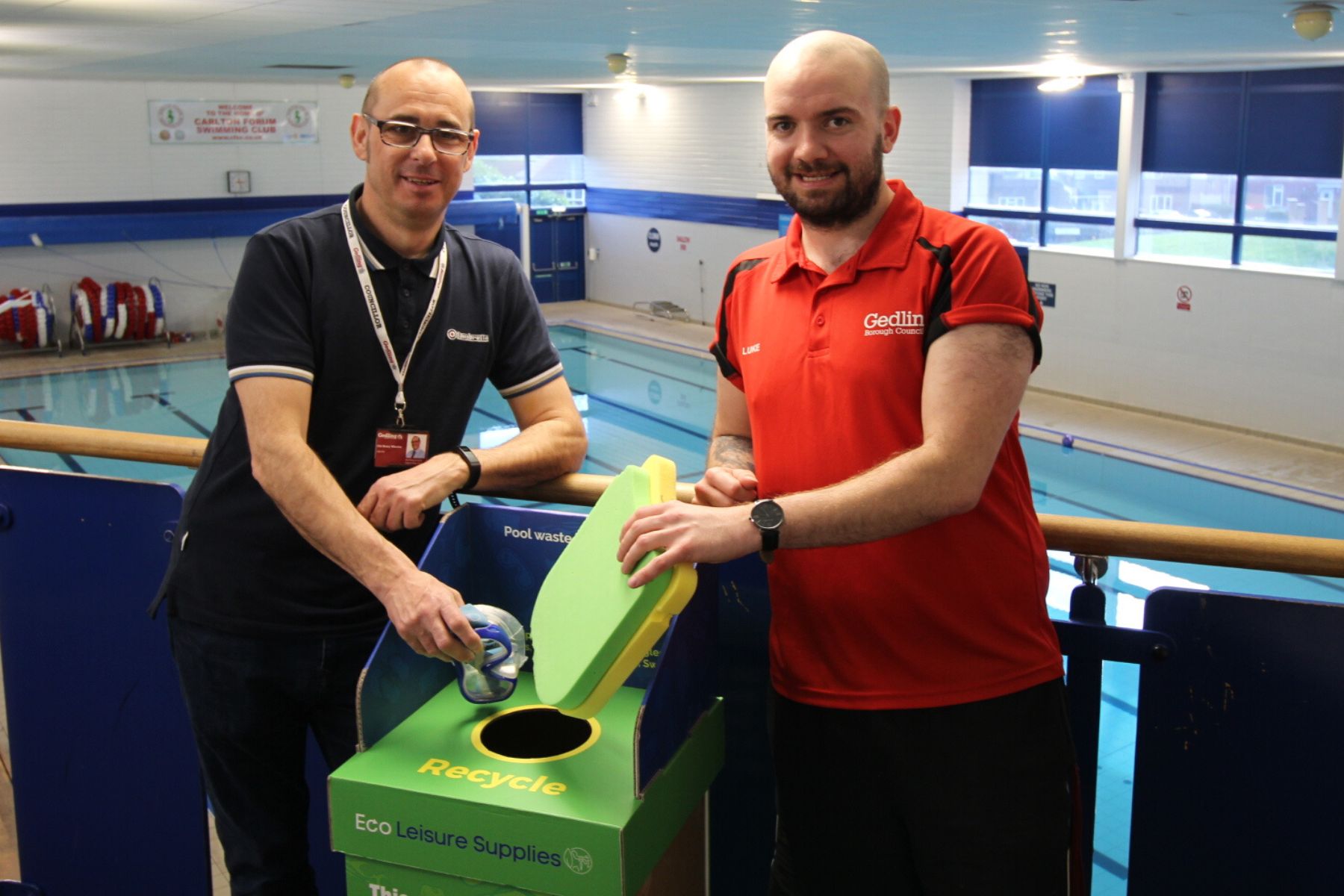 Henry Wheeler and Luke from Carlton Forum stood next to a recycling bin holding some goggles.